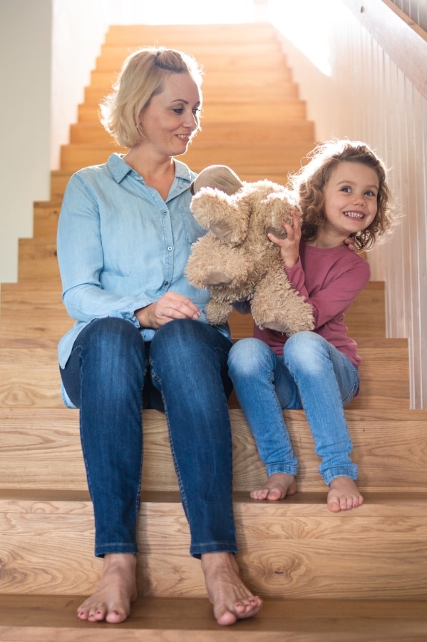 Žena s dítětem na schodech v čisté domácnosti